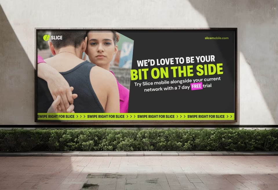 Billboard advertisement for Slice Mobile featuring a couple, promoting a 7-day free trial for adding a second phone line alongside existing networks.